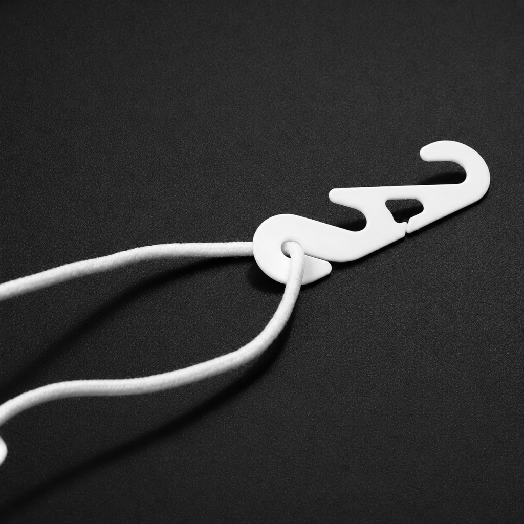 White plastic mask earloop extender hook applied on a folding mask for comfortable fit
