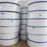 Stacked white and blue medical bag shaping wire spools for large-scale manufacturing